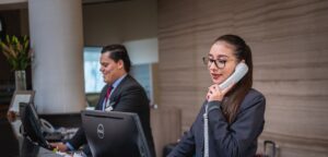 Two receptionists at their computers on the phone