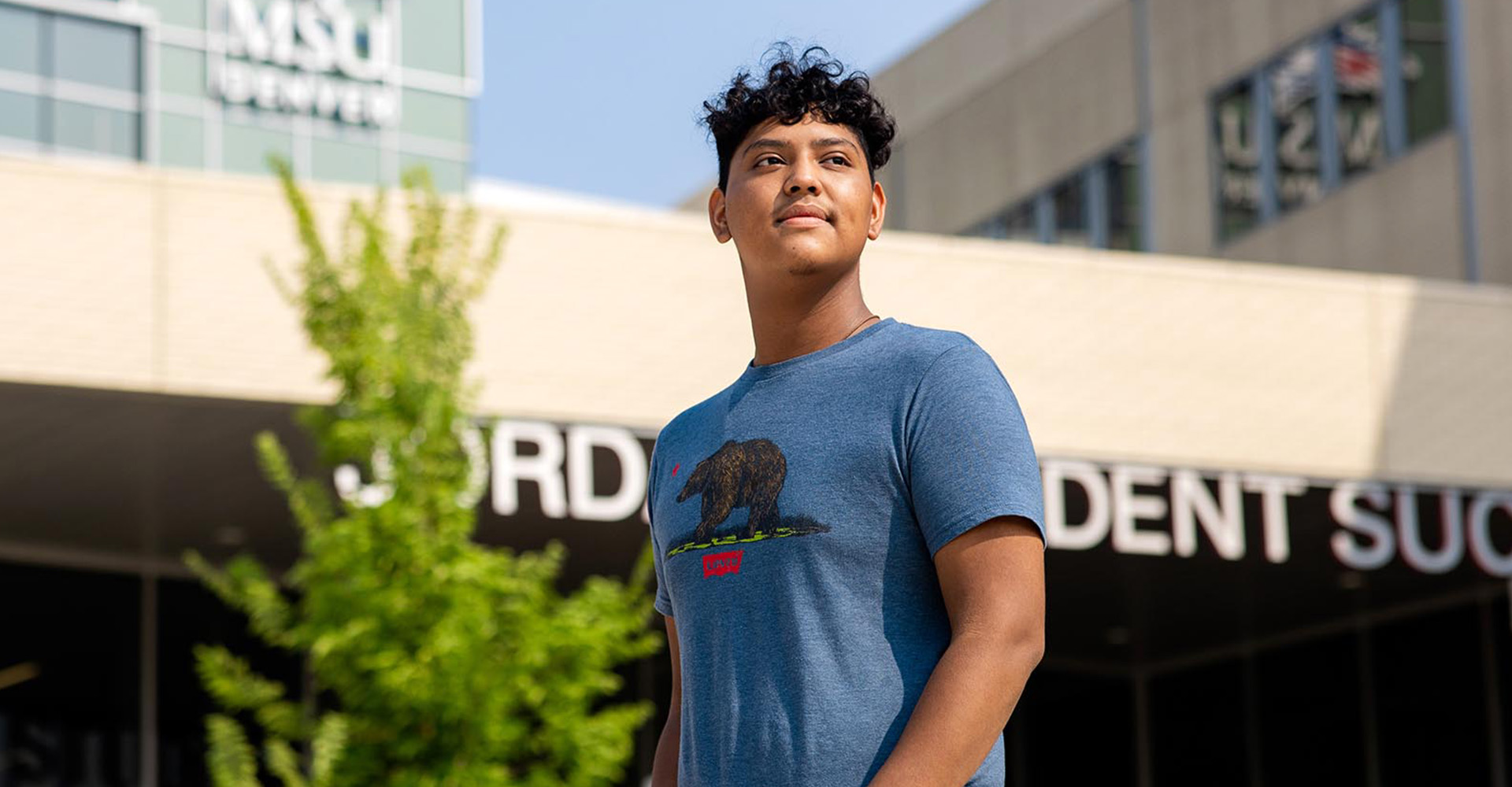 Student Luis Hernandez stands in front of the Jordan Student Success Building.