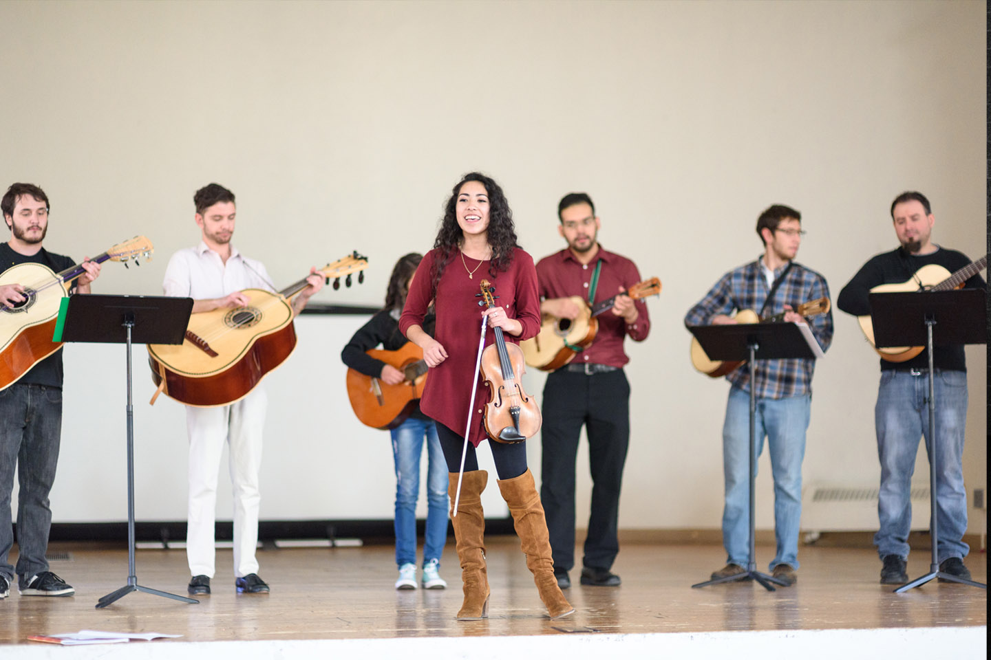 Mariachi ensemble rehearsing on a white stage