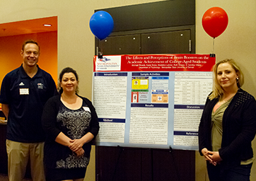 Faculty mentor and students with their conference poster.