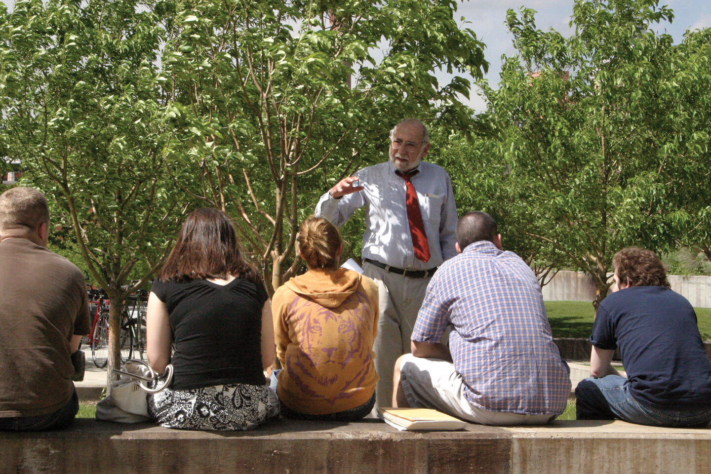 Older instructor teaching students in outside setting