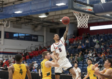 Men's basketball player Tyrei Randall skies for a left-handed layup vs. Black Hills State in 2022.