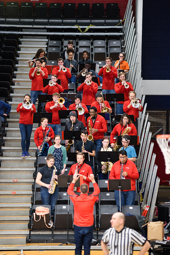 All pep band members playing in the risers of a basketball game