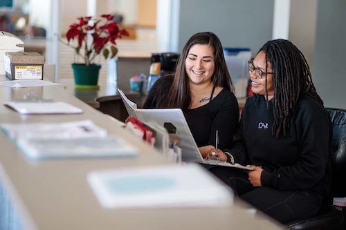 Two women discussing files