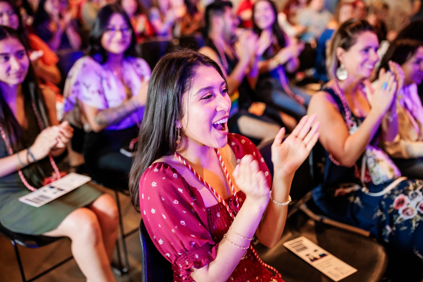 Image of graduate clapping at ceremony.