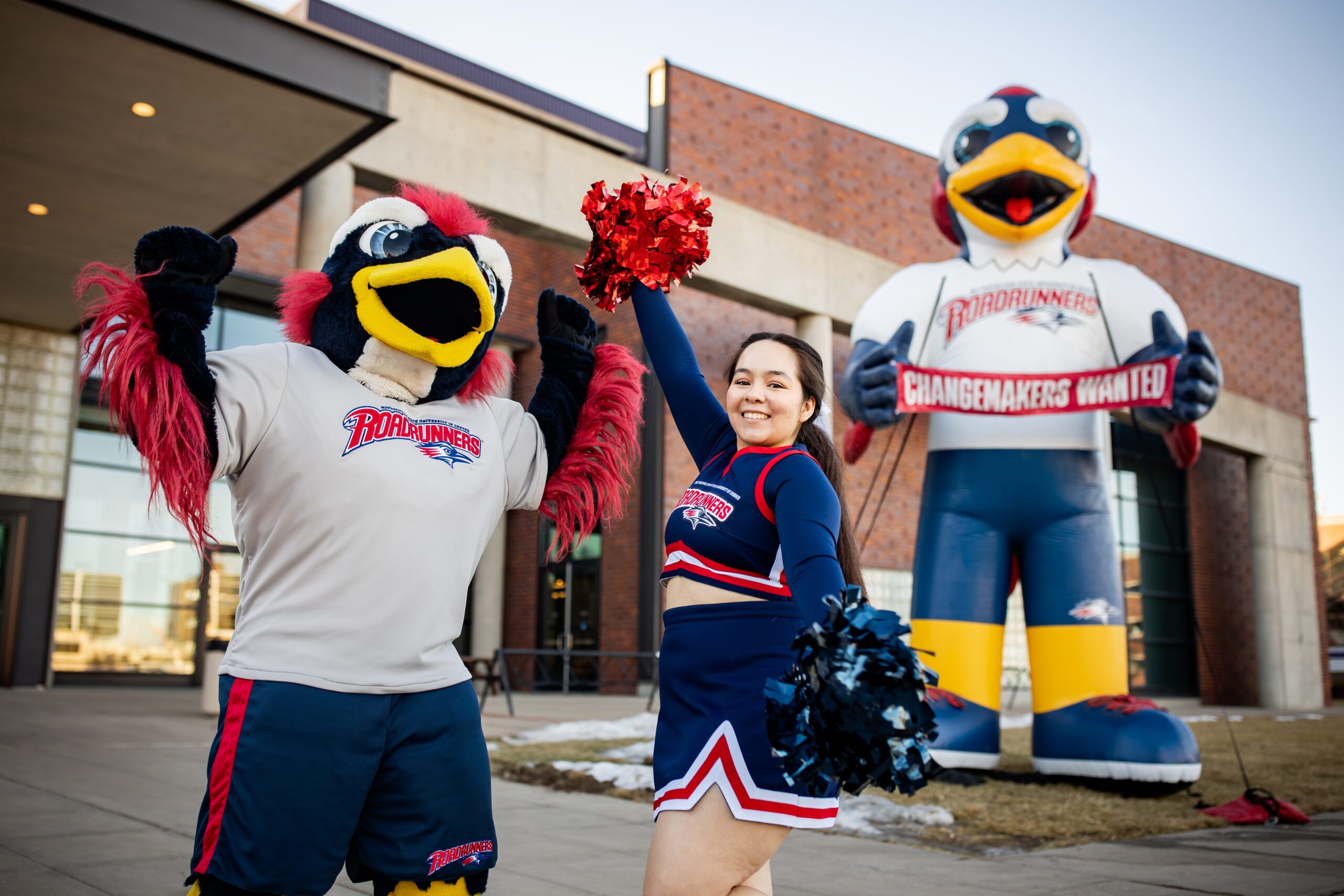 A MSU Denver cheerleader and Rowdy pose in front of a big blow-up Rowdy