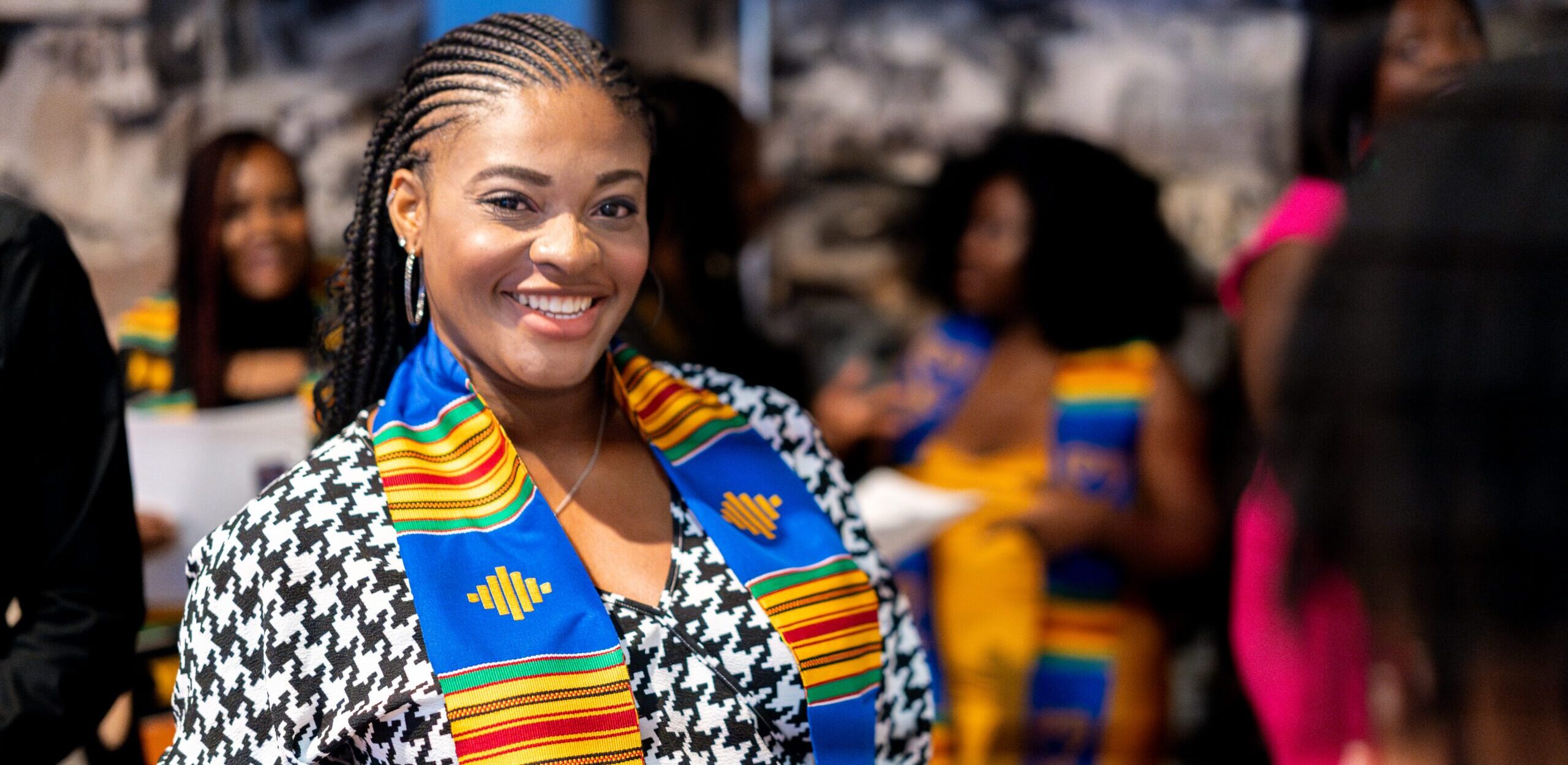 A graduate smiles after receiving their stole at the Black, African, and African American Specialty Graduation Celebration.