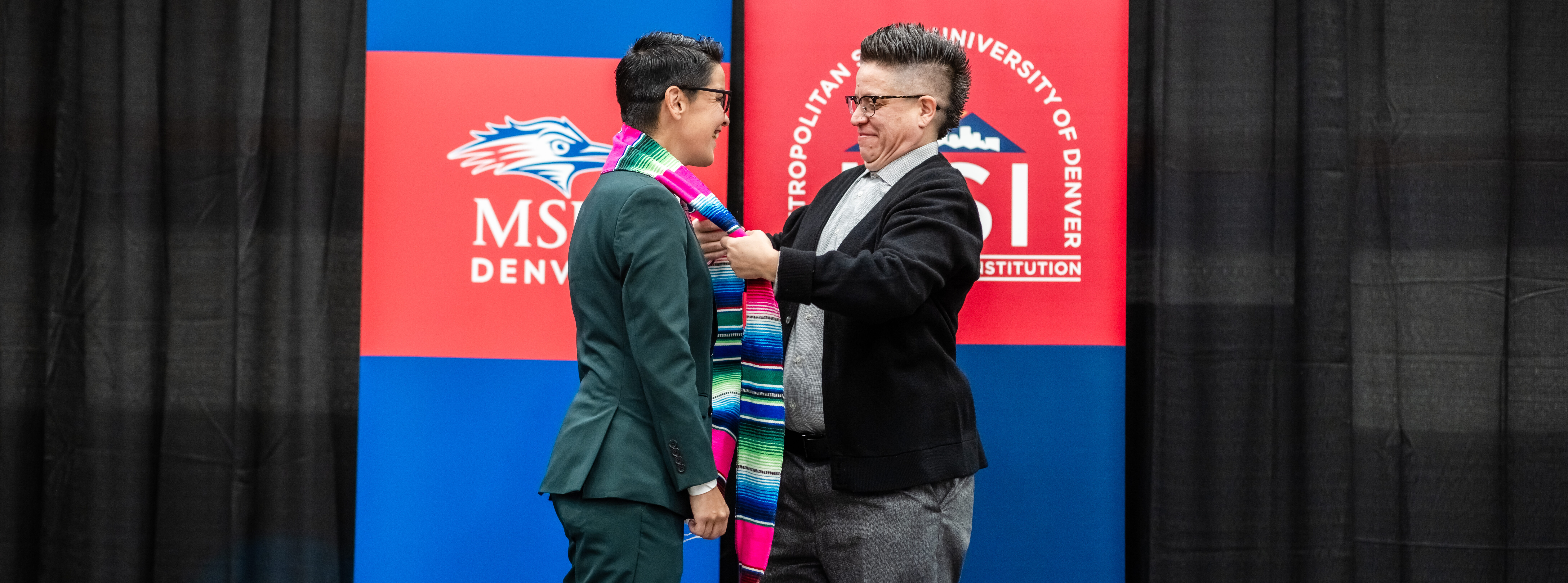 A graduate receives their Latina/o/x stole at the Latina, Latino, Latinx specialty graduation ceremony.