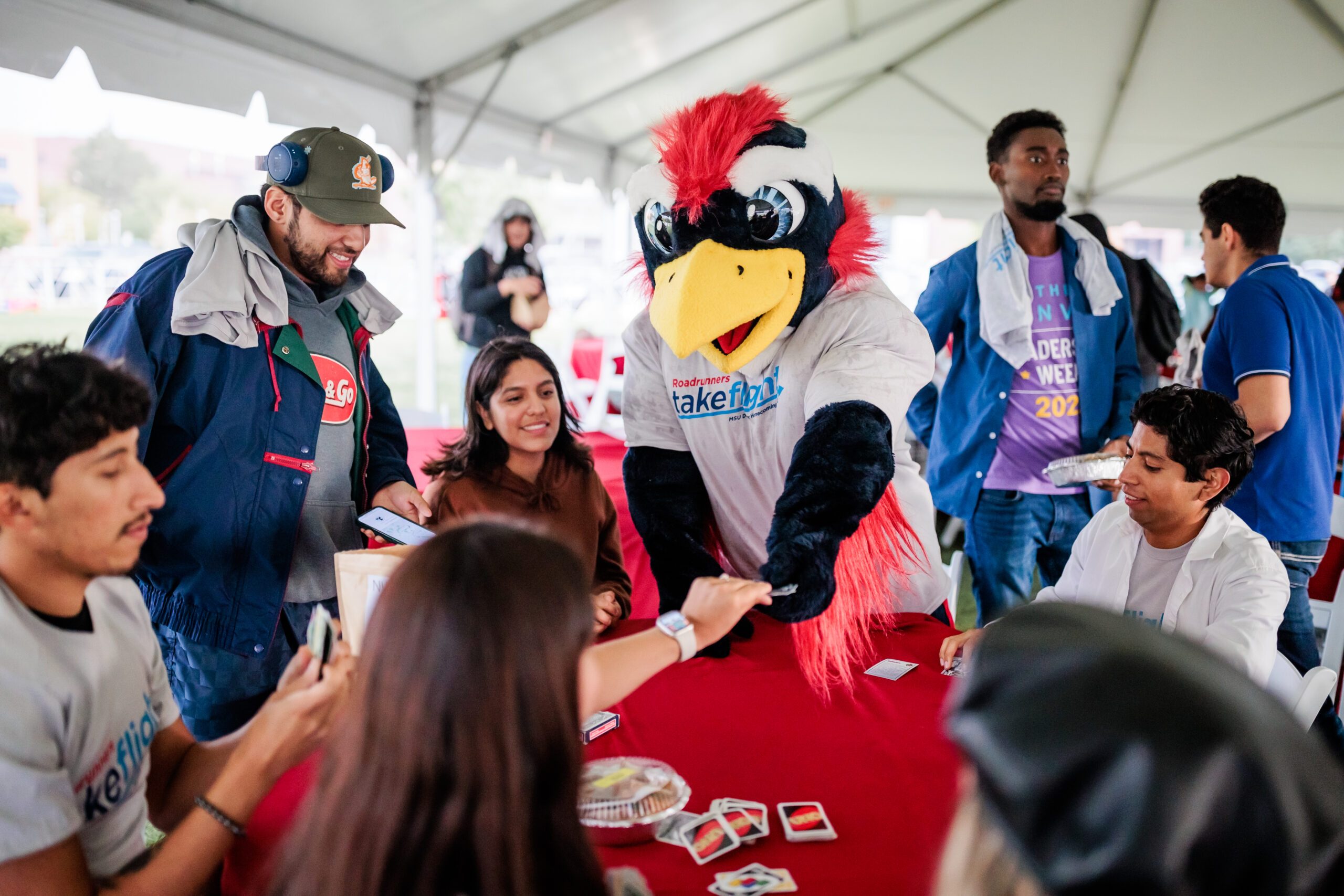 Rowdy plays Uno with a group of students