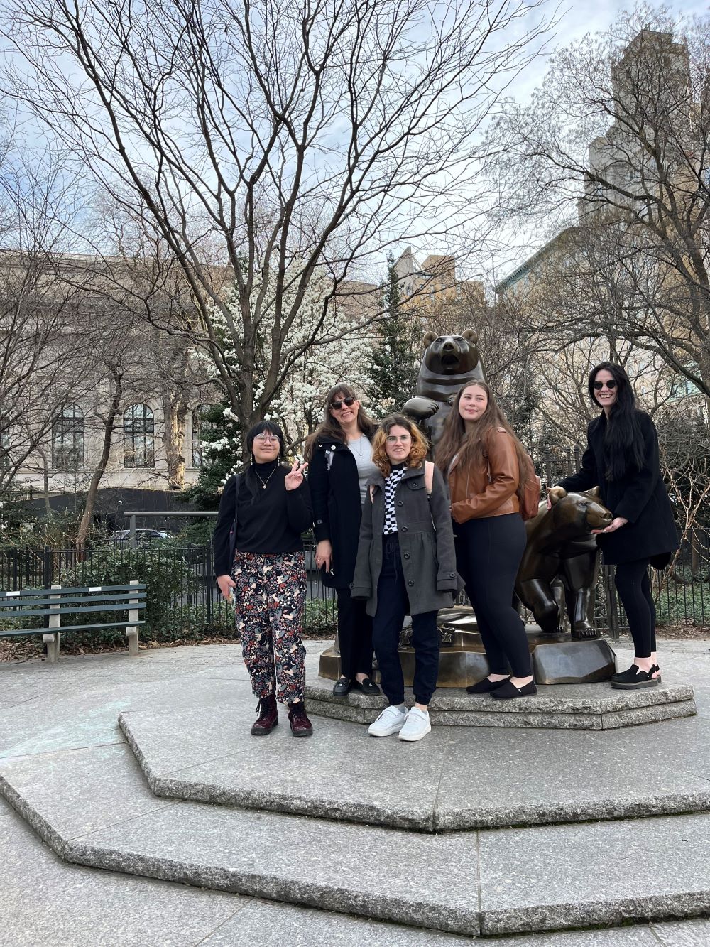 A group of MSU Denver students posing in front of a bear statue