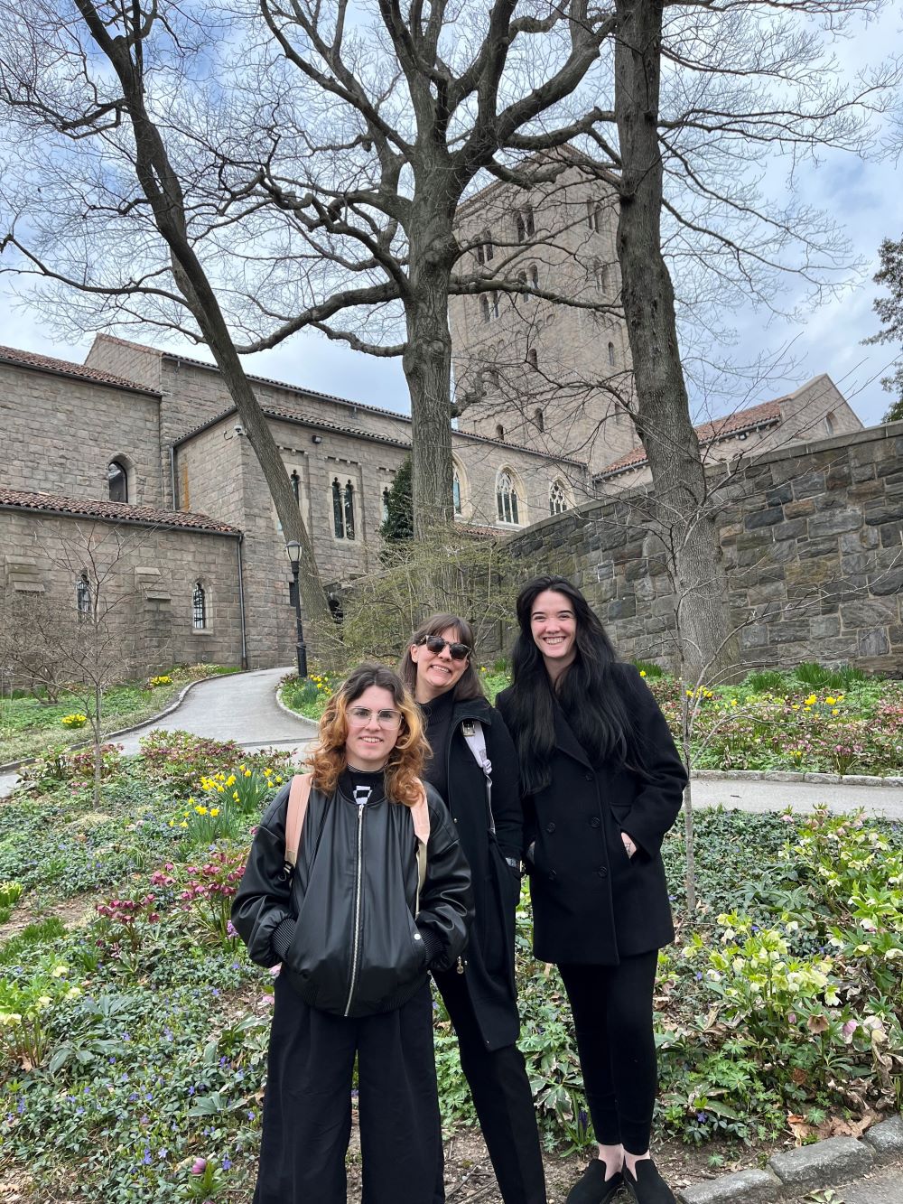 Three people standing in front of an old building