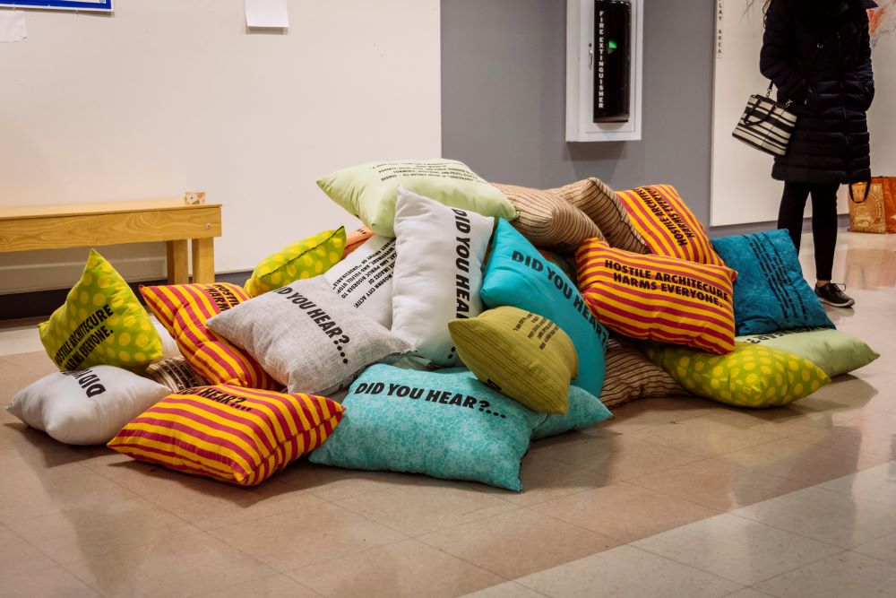 A pile of pillows with different colors and patterns with words printed in black across them