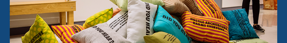 A pile of pillows with different colors and patterns with words printed in black across them