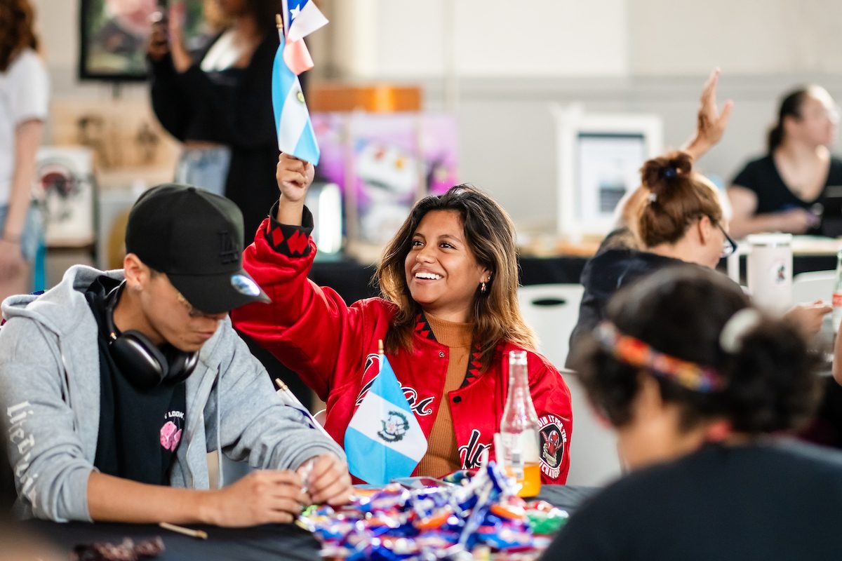 A student holding and flag and smiling