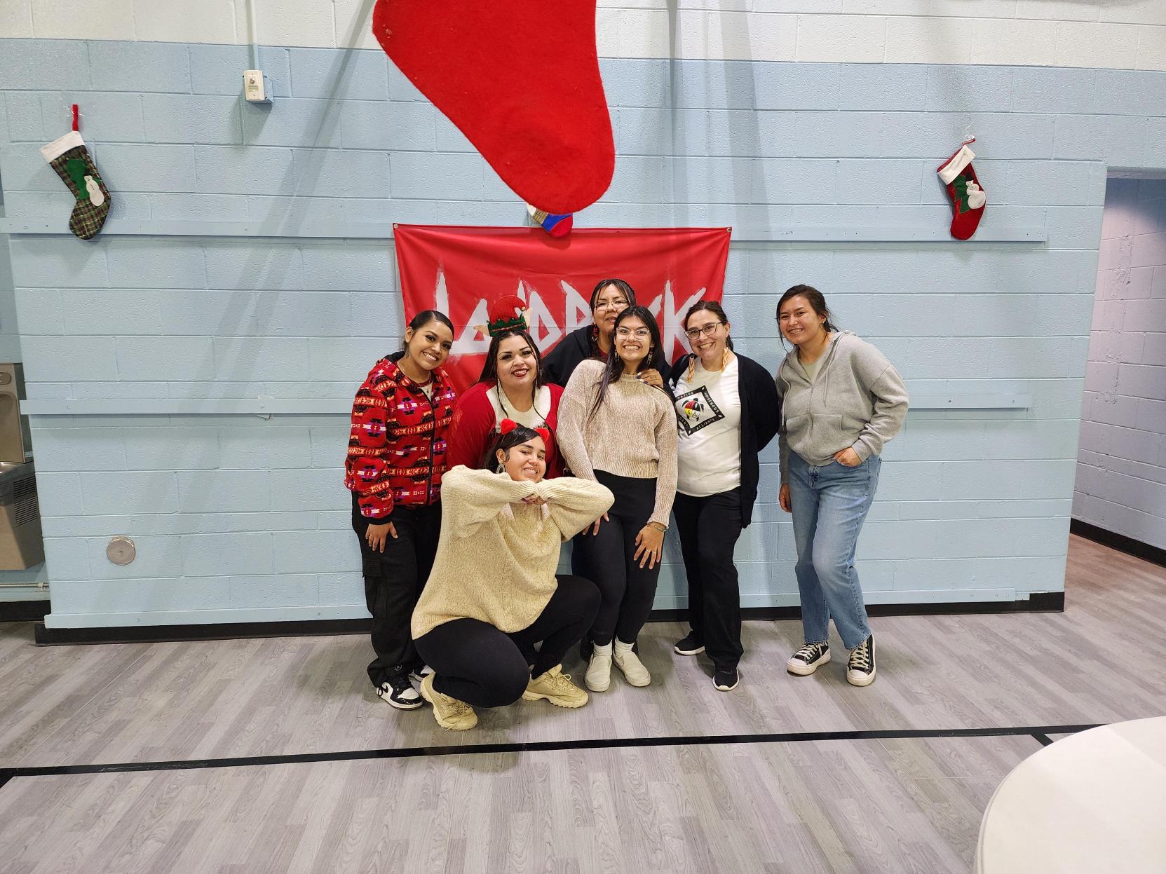 Group of students and community member pose in front of a 