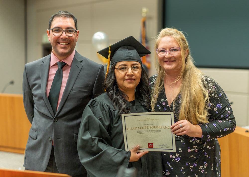 MSU Denver Staff stand with a GED Program Graduate