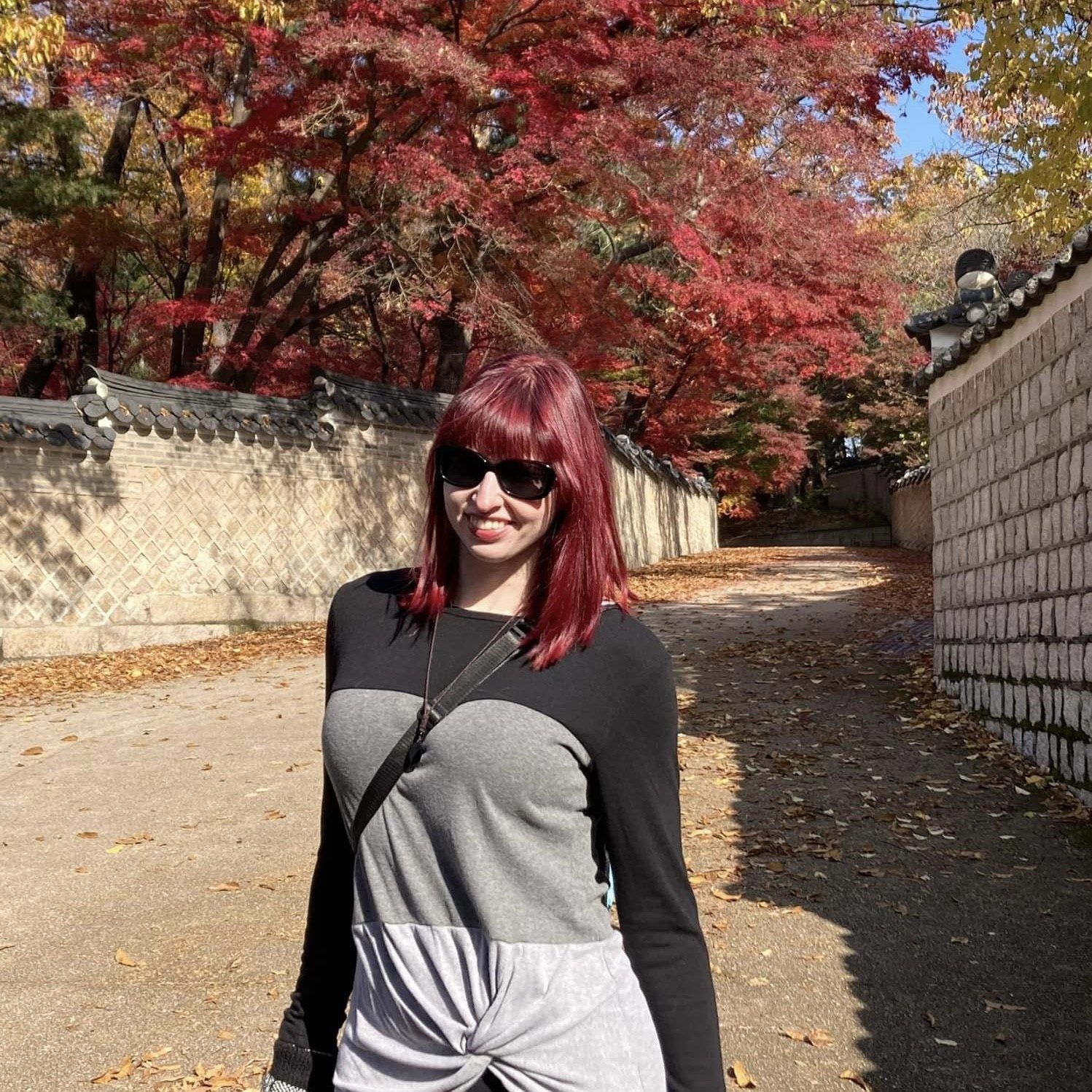 current MPAcc student - Stephanie Long headshot, standing in front of red fall foliage