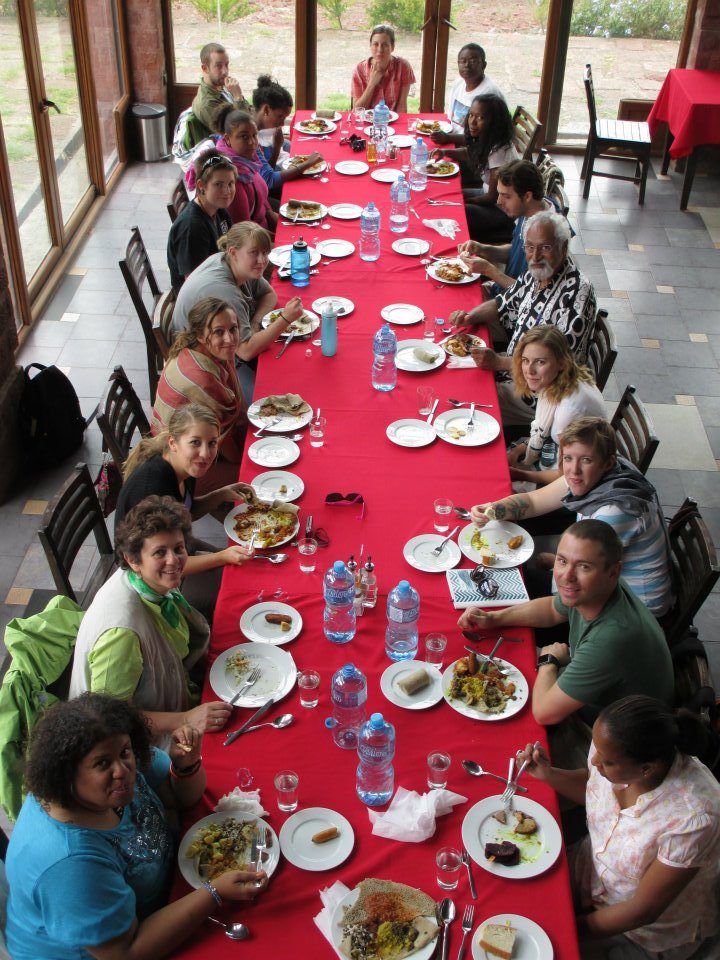 Faculty and students gathered around a long dinner table in Ethiopia