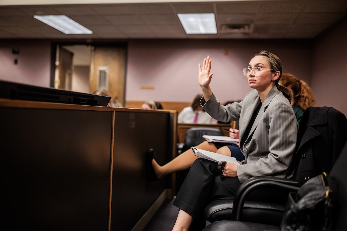 A student raises their hand during Mock Trial