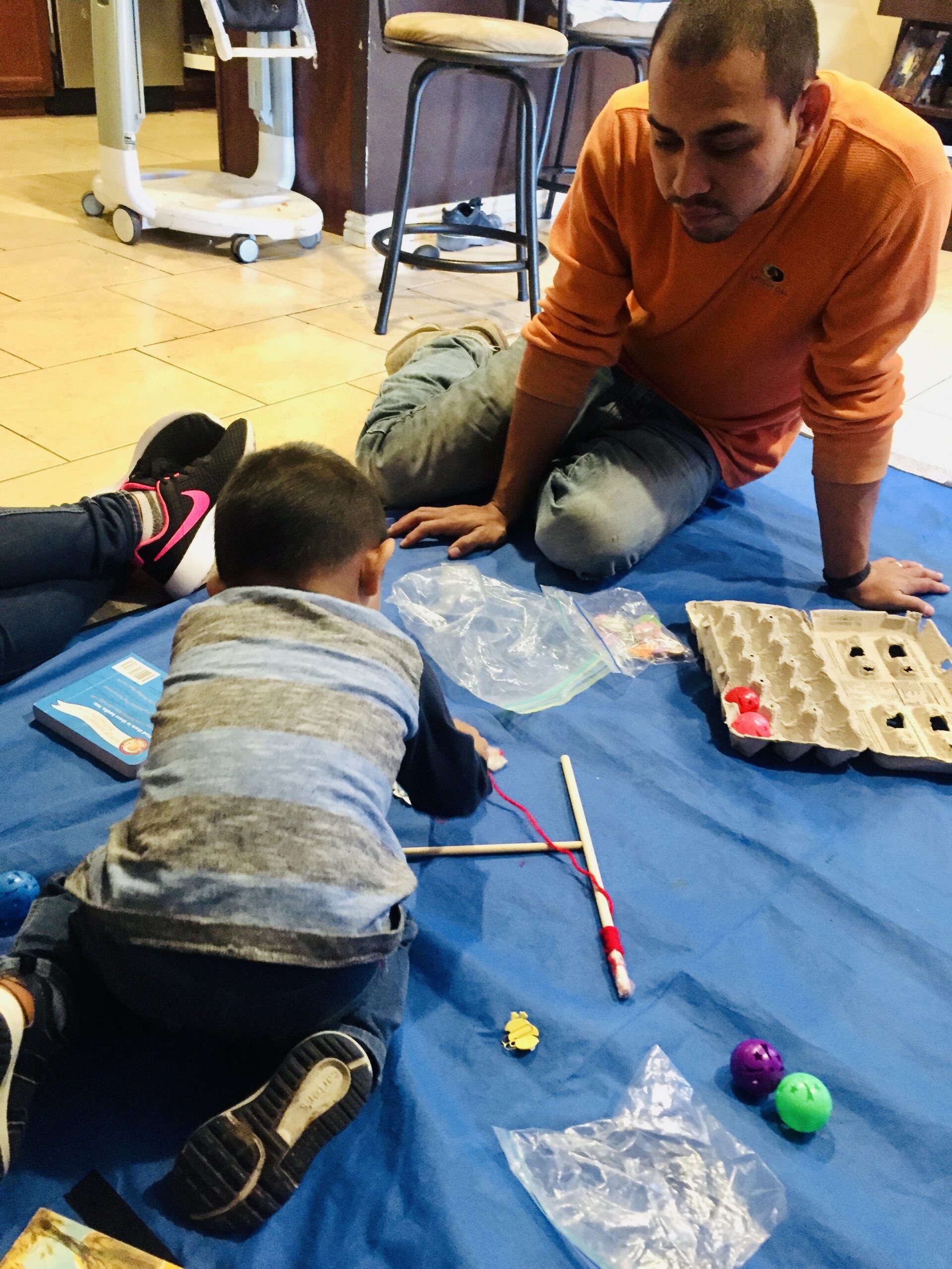 A parent and a child during a home visit work on a craft together