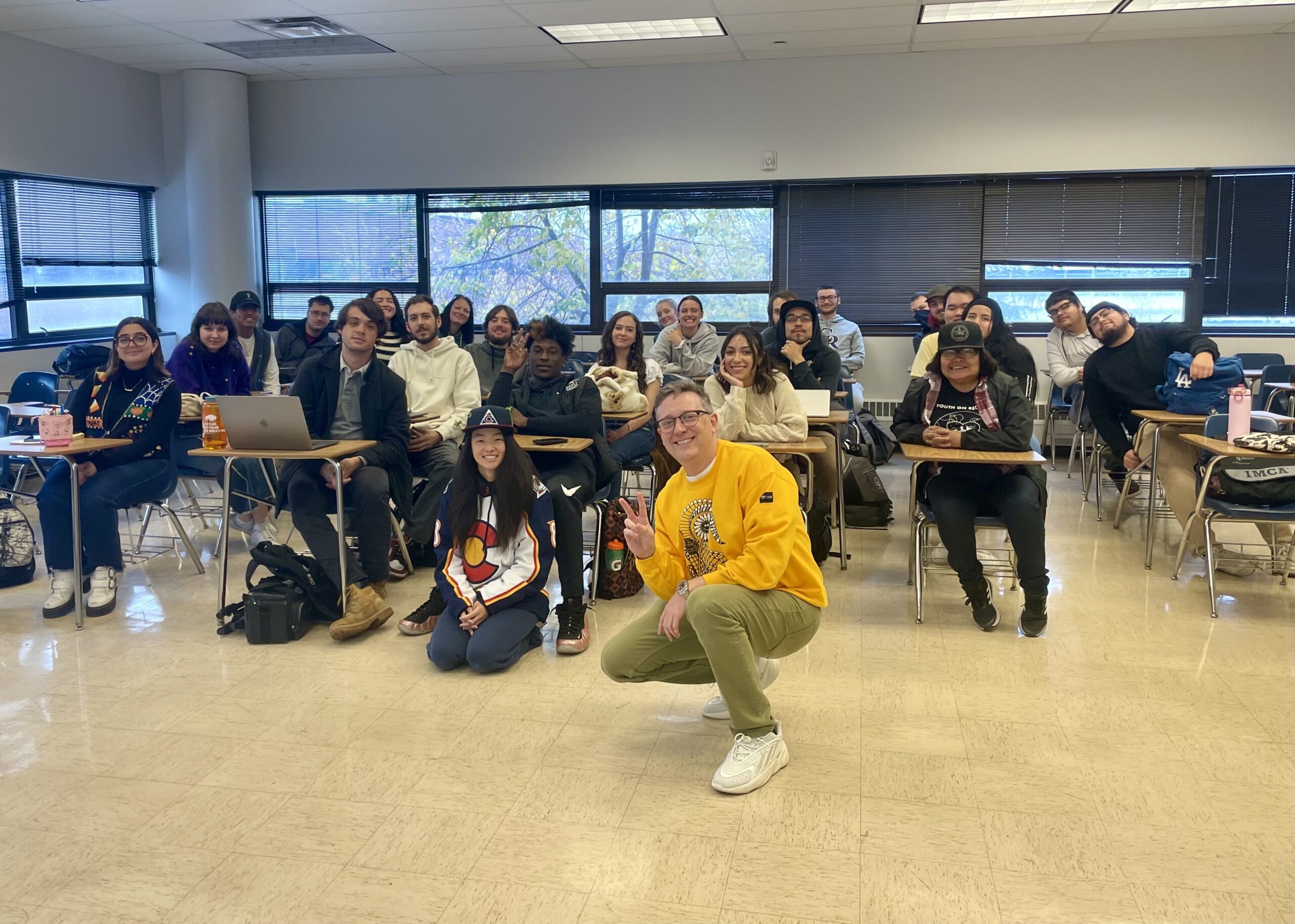 Students in Public Relations Fundaments class smile with a class visitor