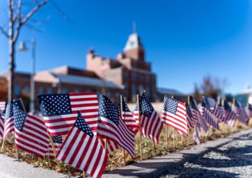 American flags in the grass in front of the Tivoli.