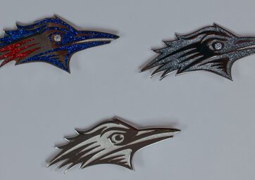 Various brooches featuring MSU Denver's Roadrunner logo.