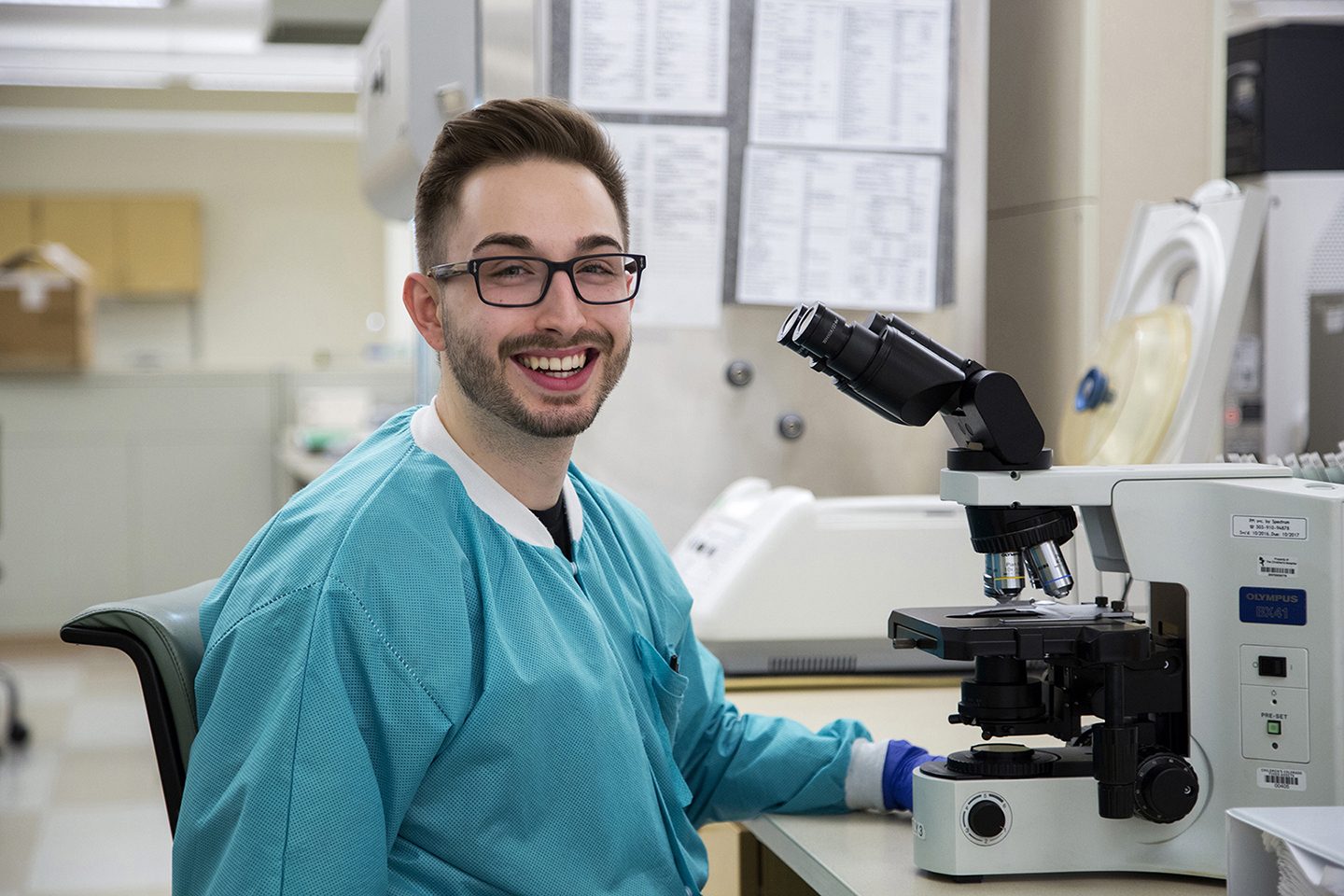 Man working in front of microscope in lab