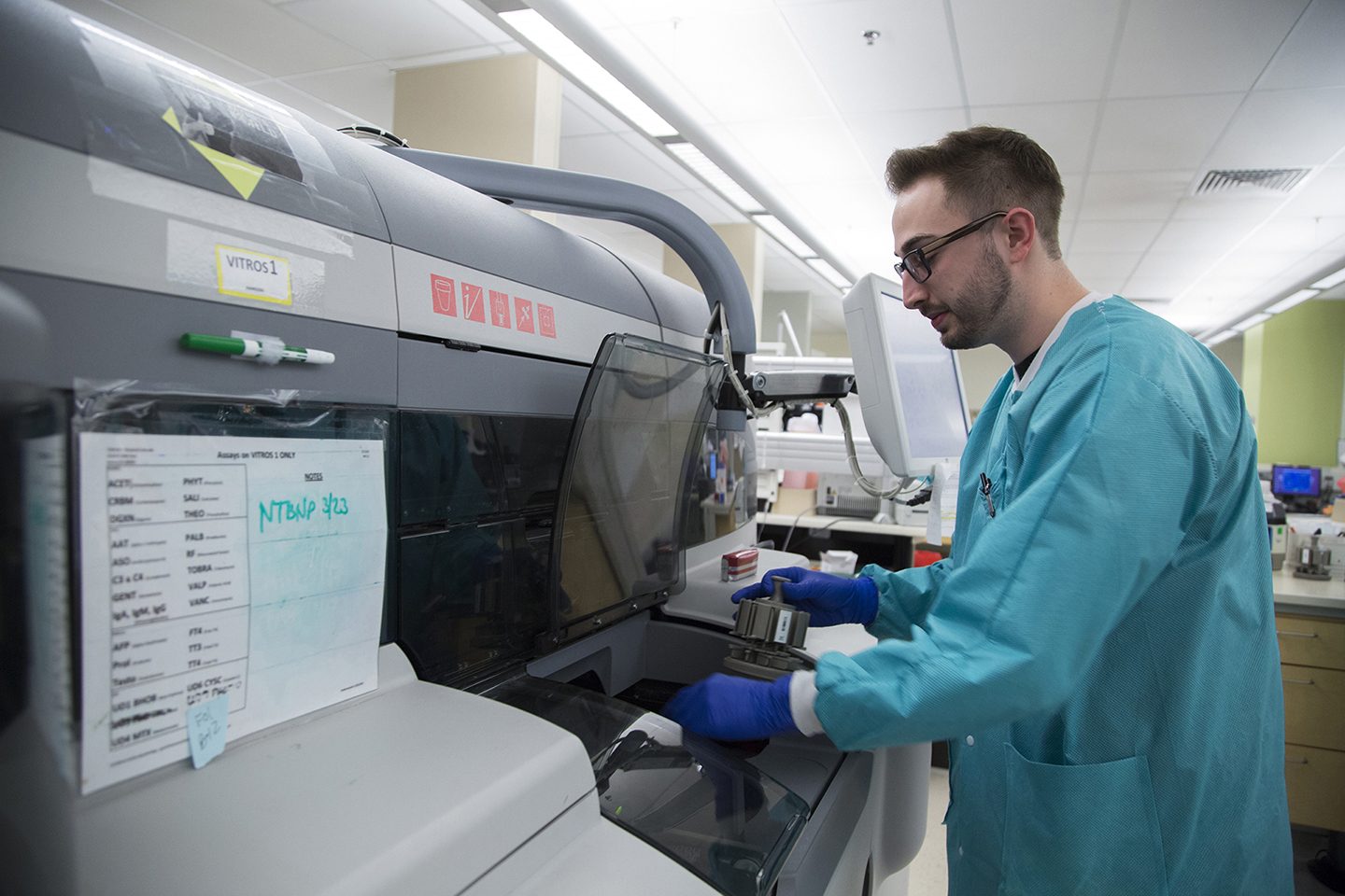 Man running medical tests in a machine in a medical lab