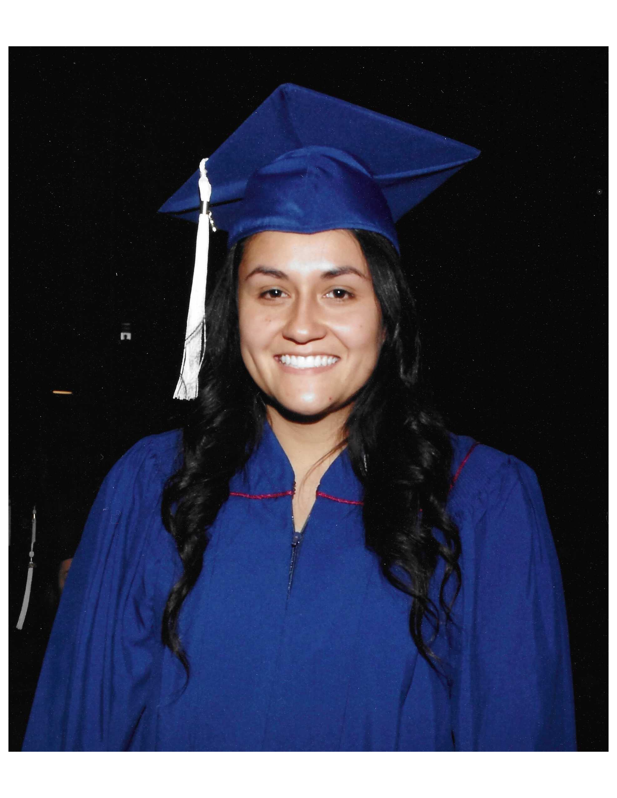 Isabel Corona Guevara smiles in her cap and gown