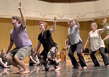 Students dancing in line on stage