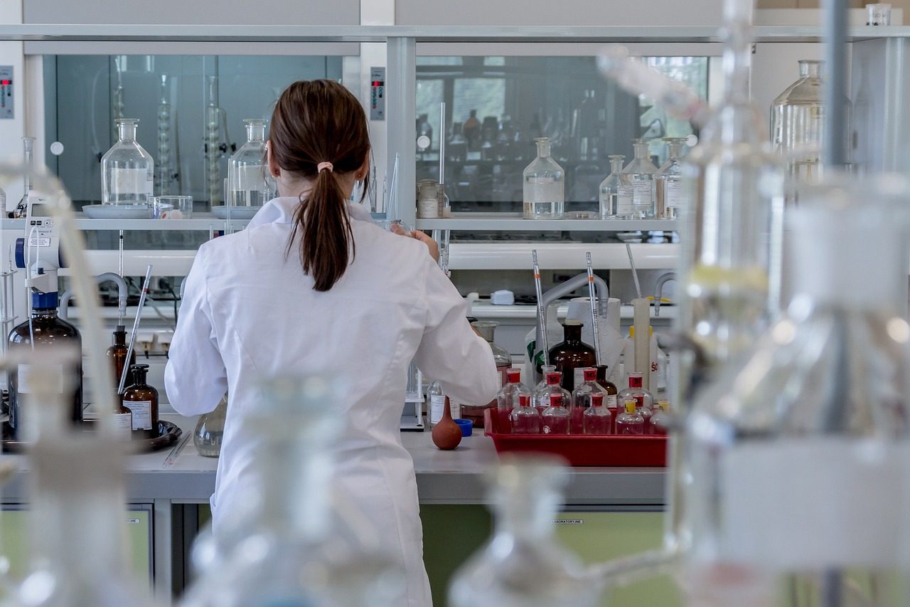 A scientist in a white coat working in a laboratory.