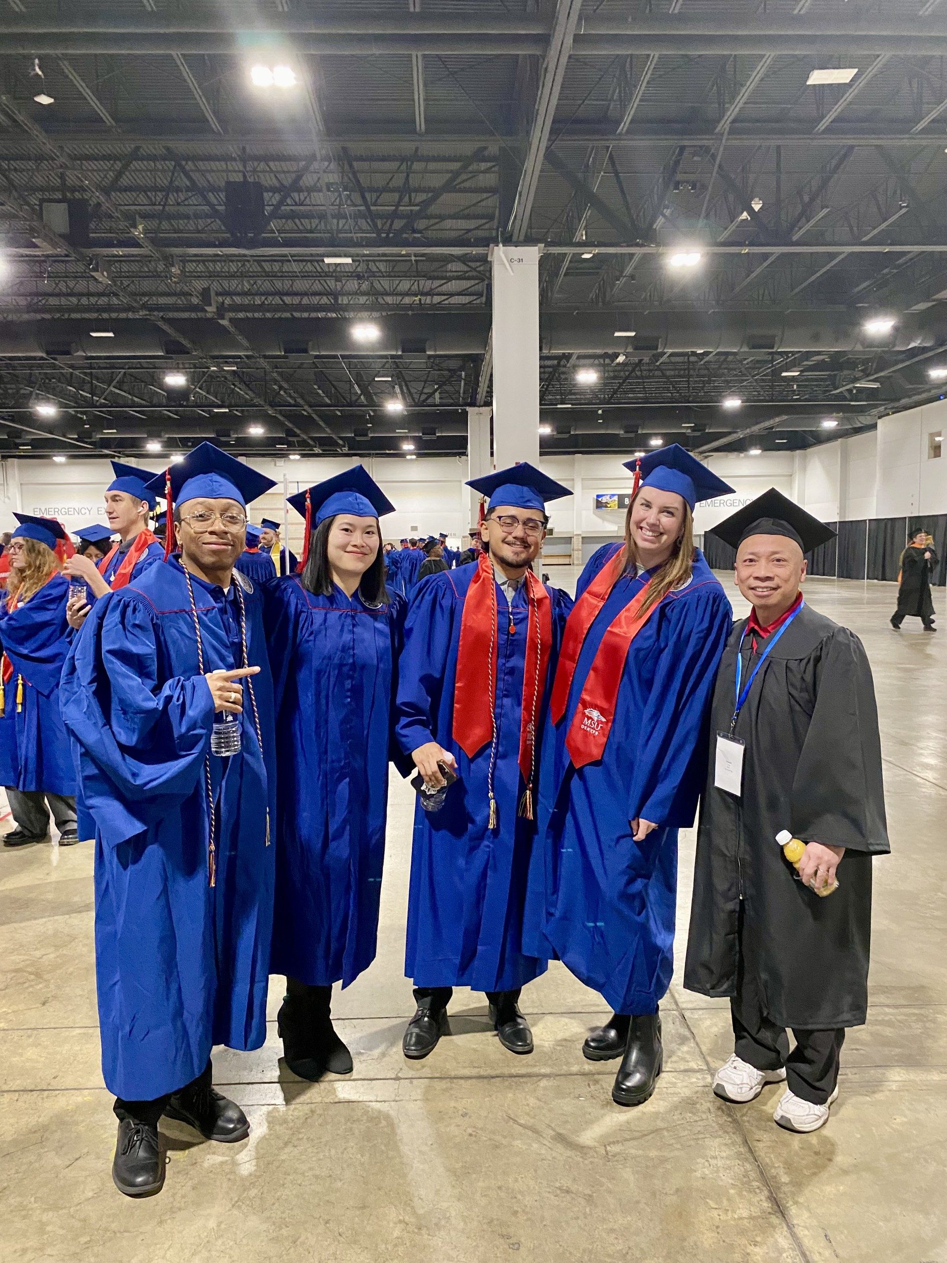 Acc advisor & 4 UG acc grads in regalia smiling at Fall '24 commencement