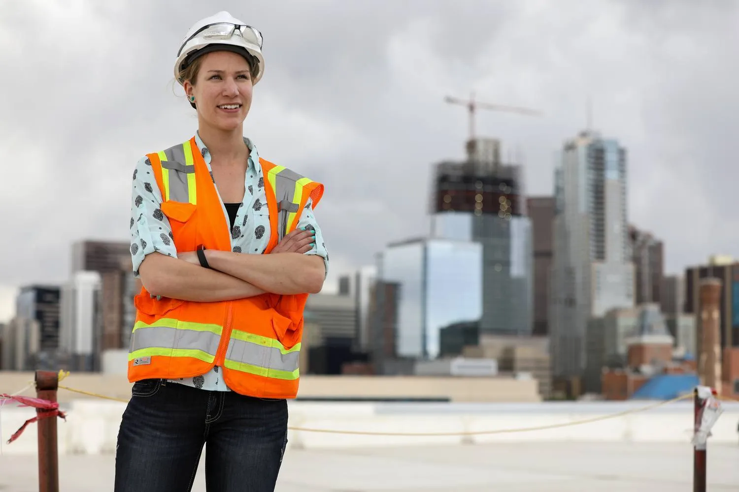 MSU Denver civil engineering technology student Allison Kassian posing with Denver skyline as background.