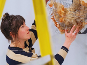 Erica Rawson makes an adjustment while installing a sculpture.